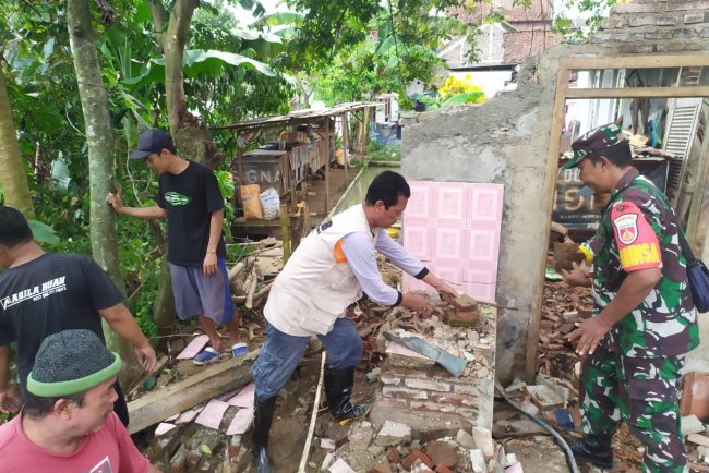 Babinsa Koramil 15/Rakit Membantu membersihakan Puing puing Rumah Warga