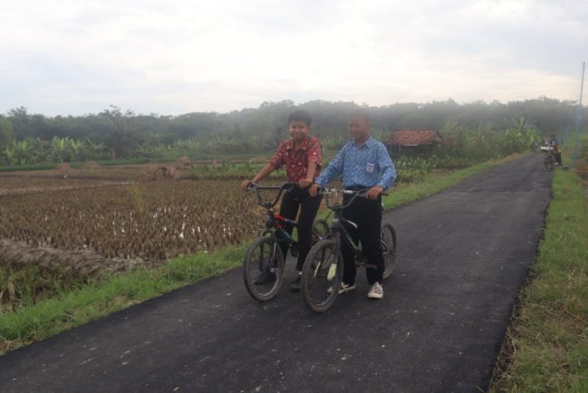 Keceriaan Anak Cikuya Saat Mencoba Gowes Sepeda diatas Aspal Jalan Baru
