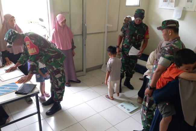 Babinsa Koramil 04 Karangkobar Bantu Bidan Desa Dampingi Giat Posyandu Balita