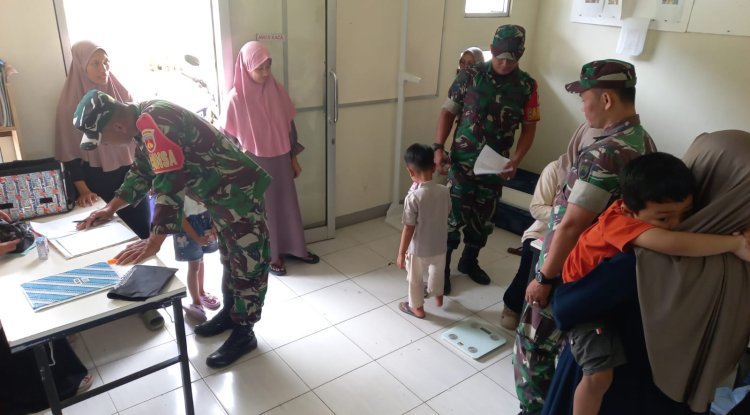Babinsa Koramil 04 Karangkobar Bantu Bidan Desa Dampingi Giat Posyandu Balita