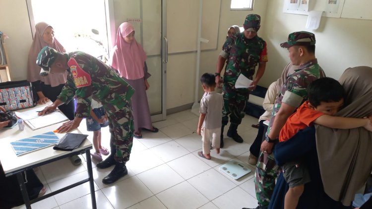 Babinsa Koramil 04 Karangkobar Bantu Bidan Desa Dampingi Giat Posyandu Balita
